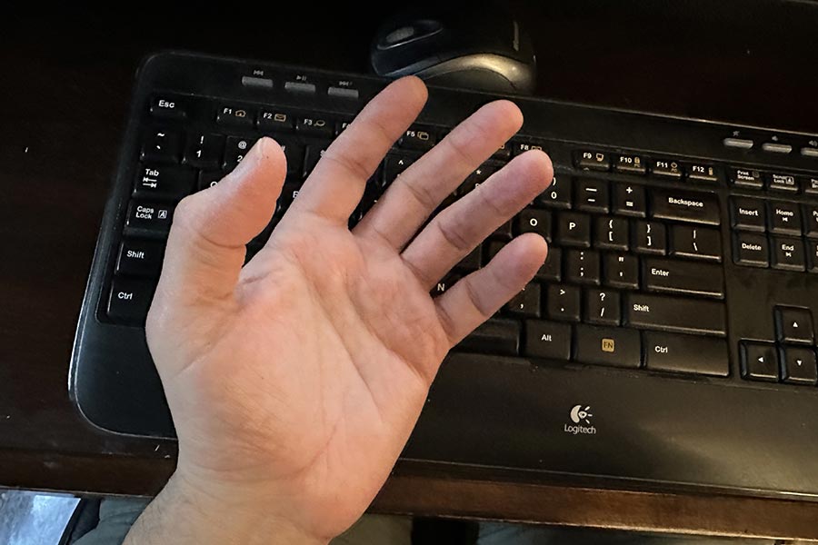 waiting online - upended hand over a keyboard